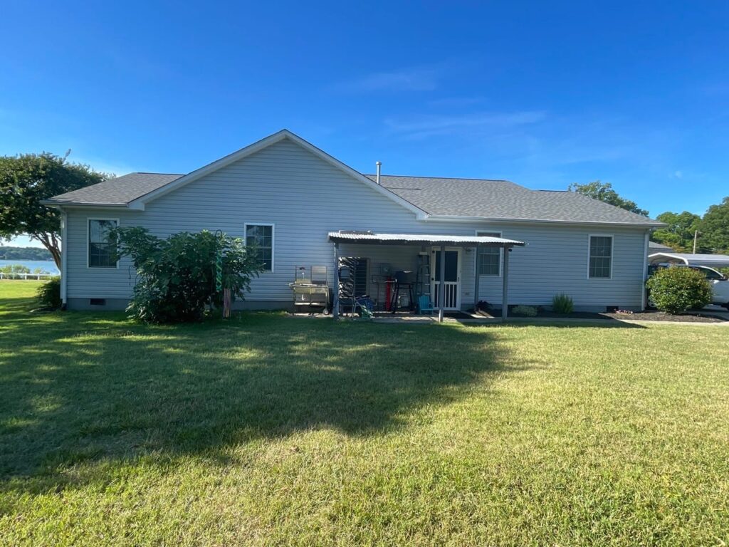 Before: plain backyard lawn behind a single-story home in Poquoson, VA