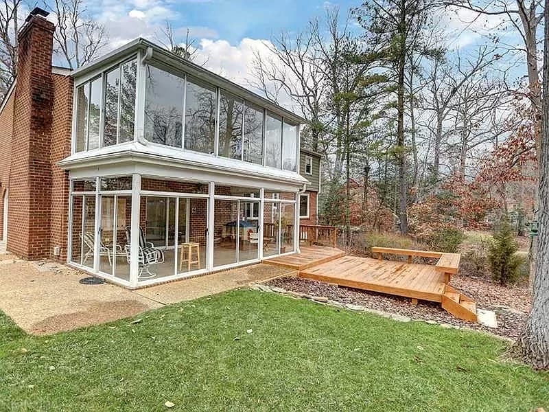 Before: backyard lawn and small wood deck behind a brick home