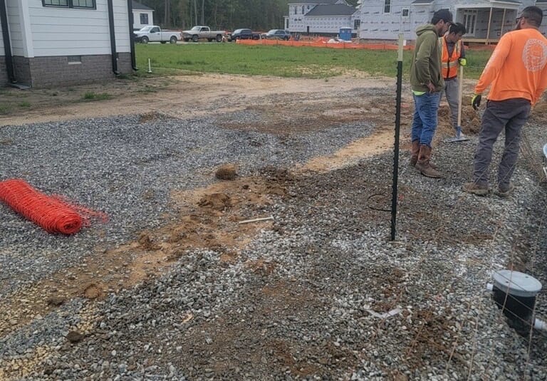 Before: graded dirt and gravel backyard with crew on site in Tabb, VA