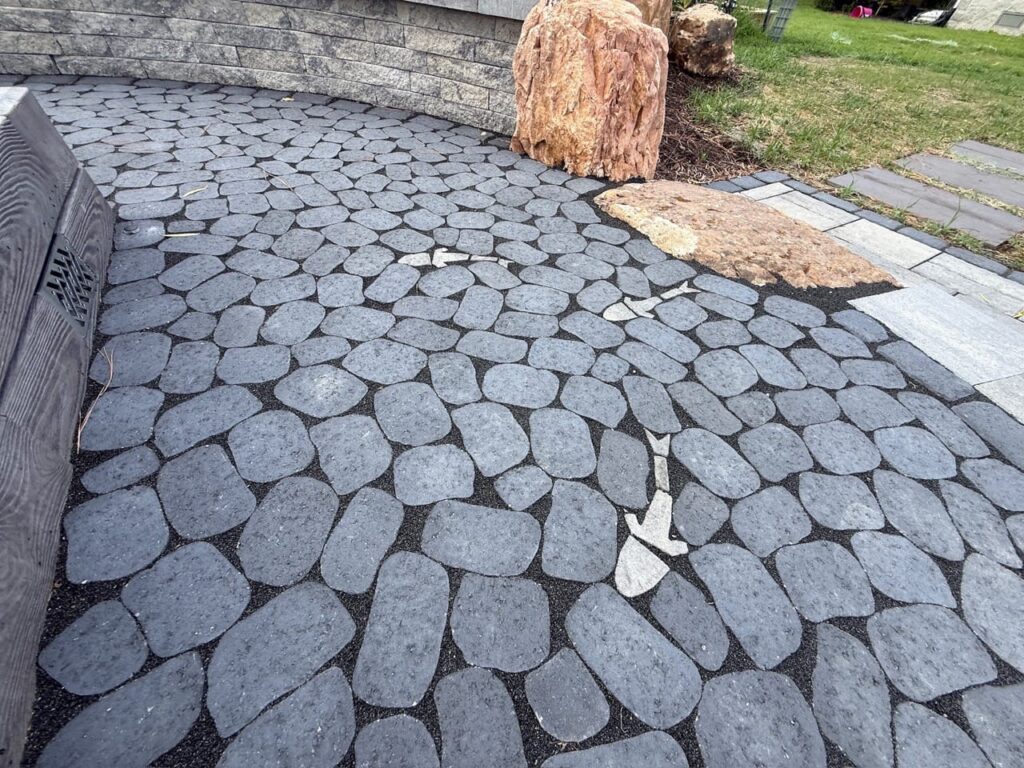 Stone-look cobble paver patio with inlaid fish accents in Poquoson, VA