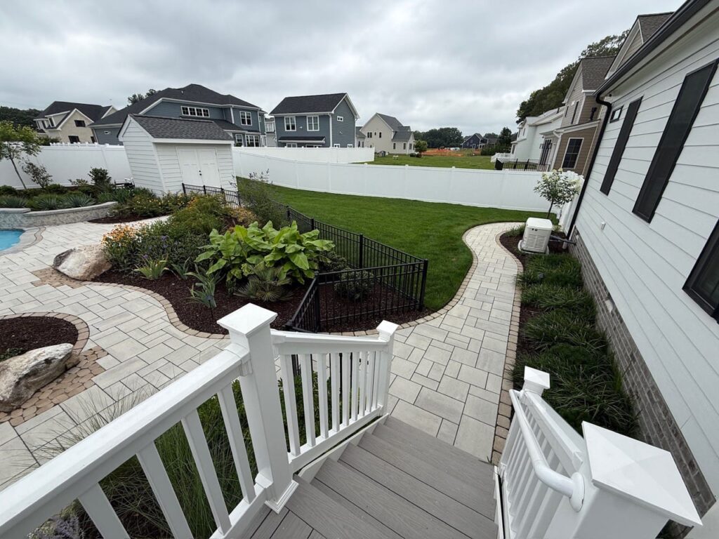 Deck stairs leading down to a paver walkway and lawn in Tabb, VA