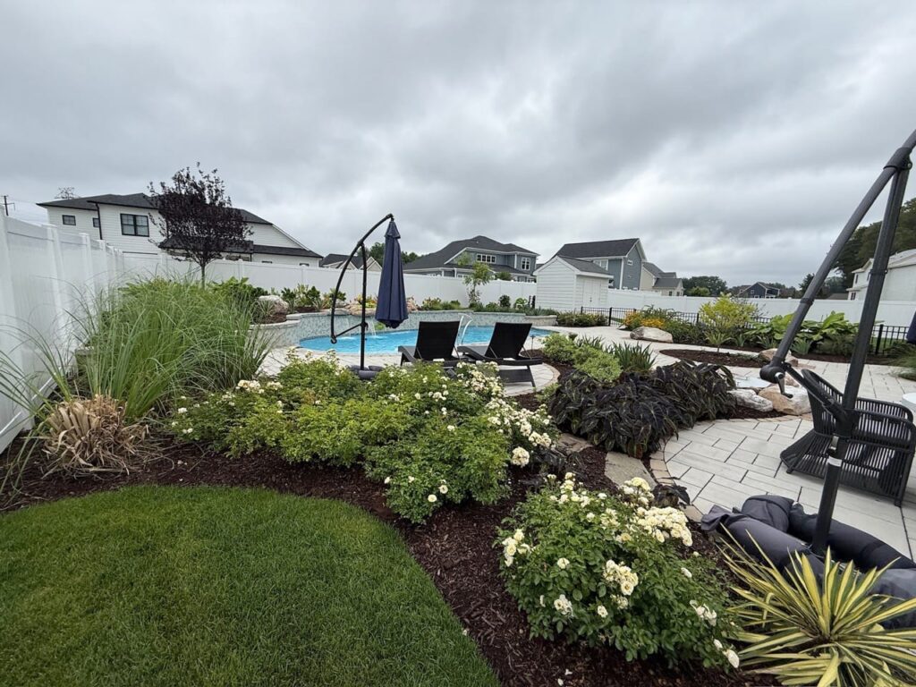 Flowering landscape beds and lawn beside the pool area in Tabb, VA