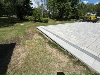 Large paver patio edge with contrasting border band and lawn