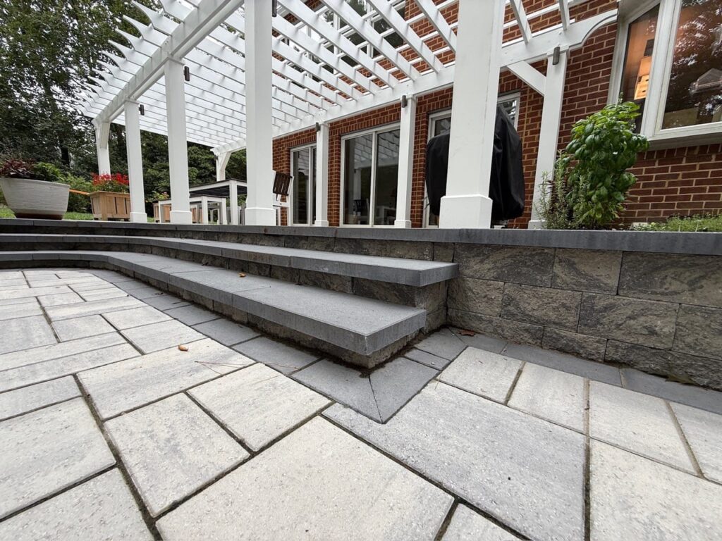 Wide paver steps and patio along a brick home