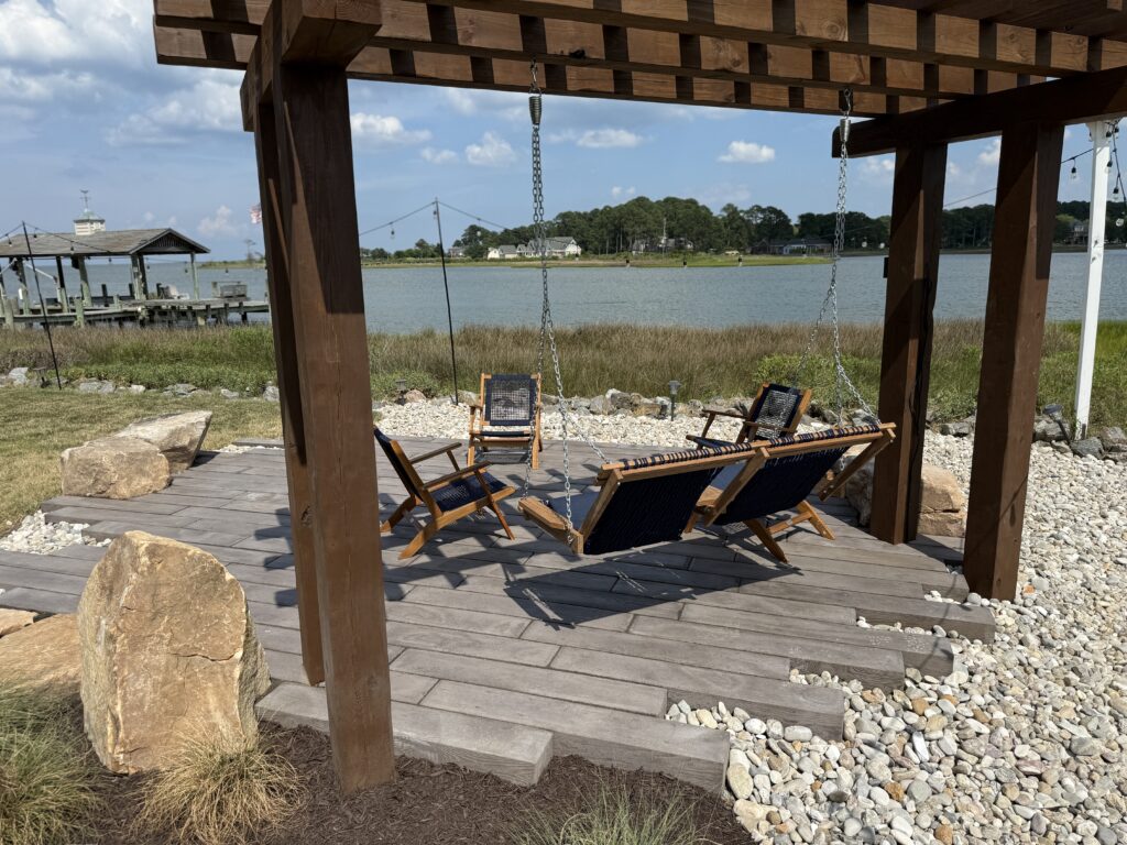 Timber pergola with chairs on a plank paver patio by the water in Poquoson, VA