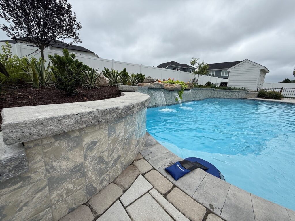 Raised natural stone wall at the edge of a pool in Tabb, VA