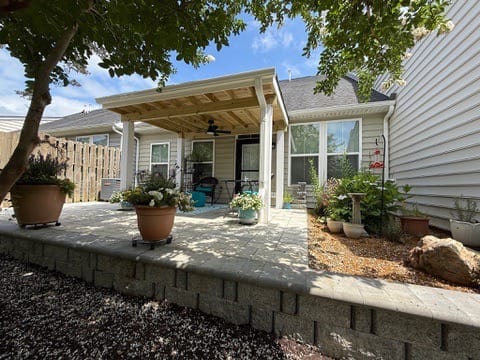 Raised paver patio with block wall and covered porch