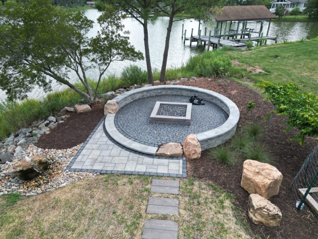 Round raised paver fire pit patio with steppers near the water in Poquoson, VA
