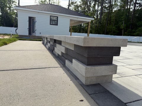 Two-tone paver seating wall with light cap on a patio