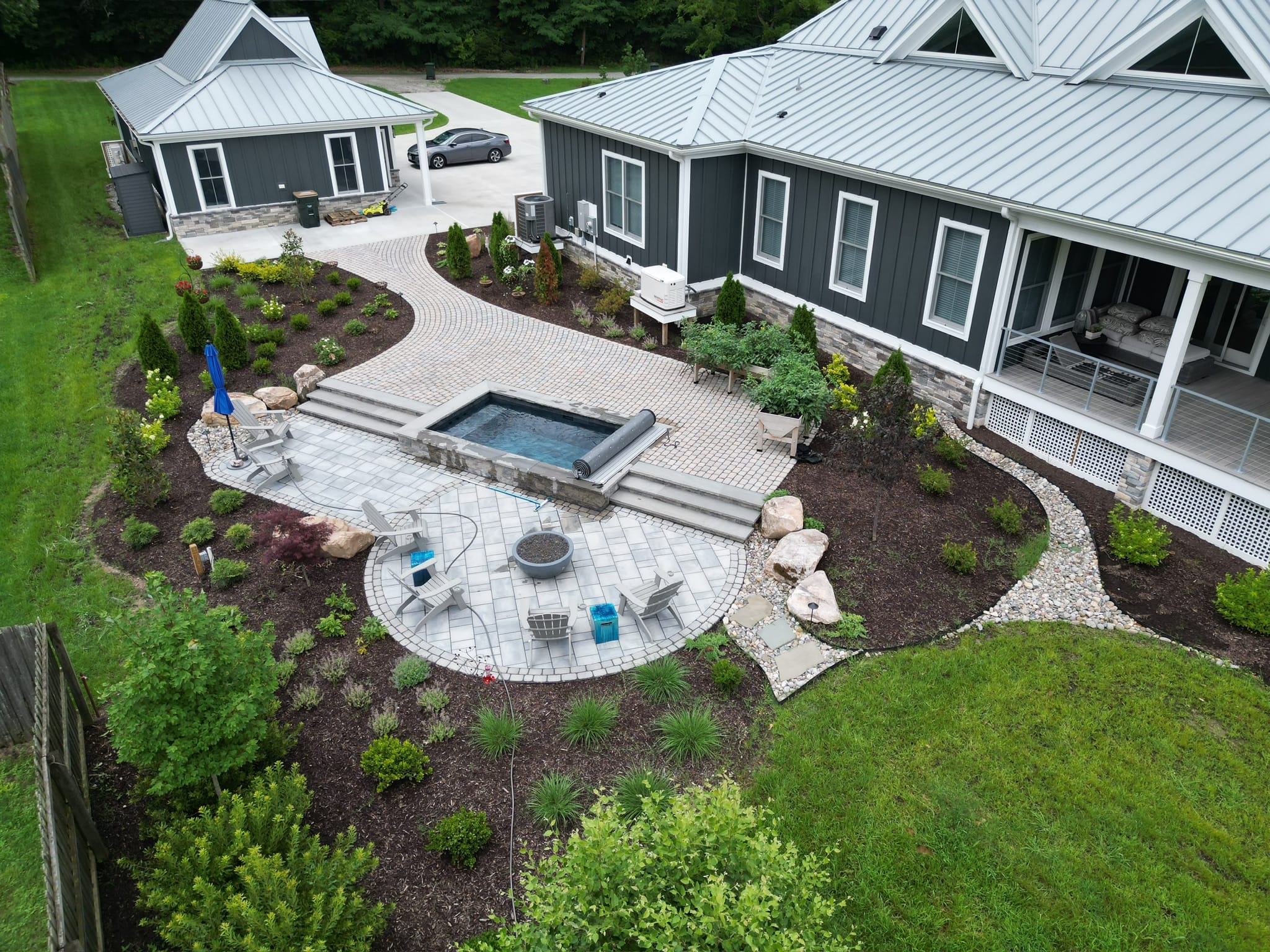 Aerial view of a plunge pool with paver patio, fire pit area and landscaping in Yorktown, VA
