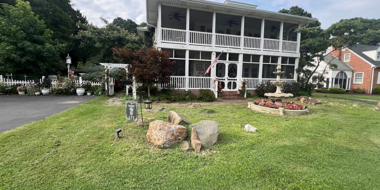 Before: plain front lawn with a few boulders in front of a two-story home in Poquoson, VA